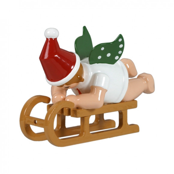 Weihnachtsengel auf Schlitten liegend mit Mütze