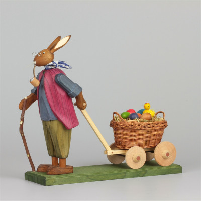 Osterhasengroßvater mit kleinen Eiern im Handwagen